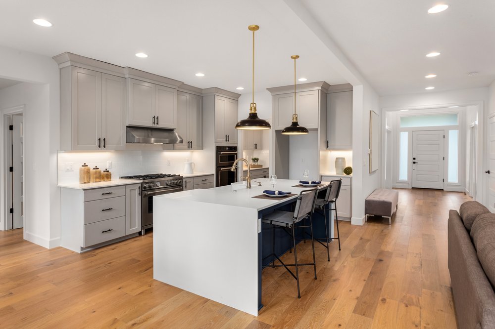 A kitchen with a center island next to a living room